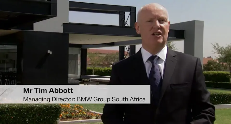 Tim Abbott speaking outside a modern BMW building