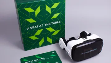 Virtual reality headset beside green promotional display box