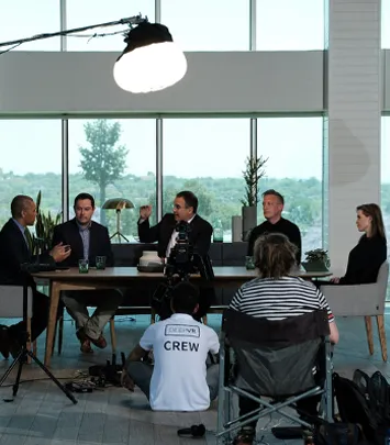Film crew records four people in bright studio interview